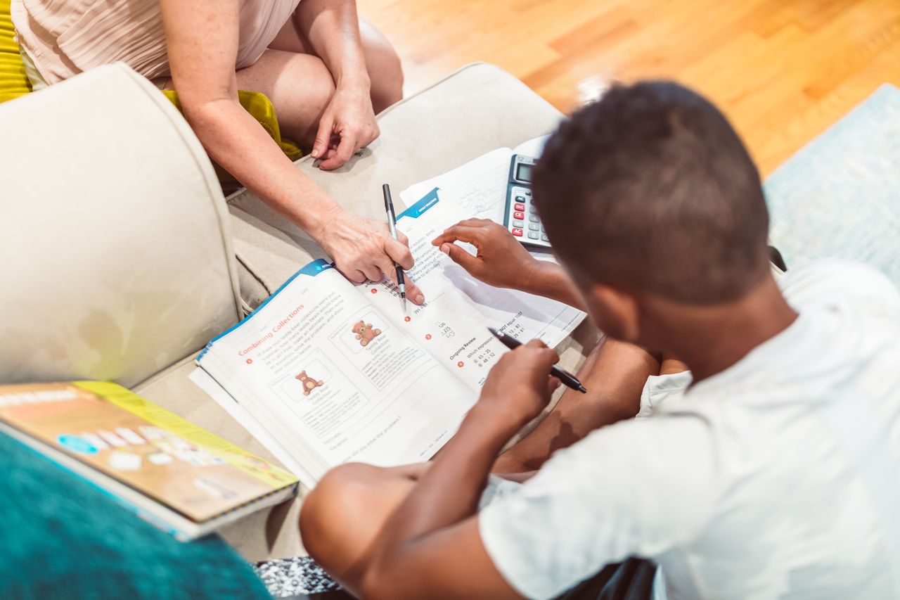 hero-img-01 A child receives tutoring assistance with homework, highlighting education and learning.
